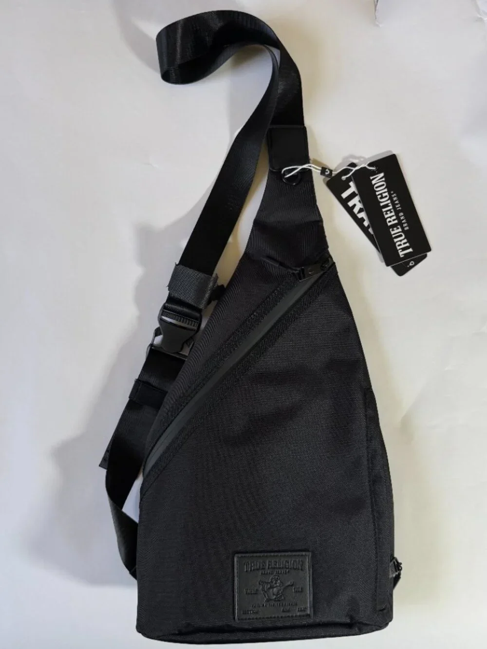 True Religion Black Sling Bag Features a Textured Black Logo Patch on the Front